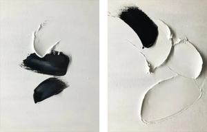 A pair of hand-painted abstract paintings with thick 3D black and white impasto textures, hanging above a wooden table in a Zen-style minimalist room.