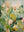 A vertical hand-painted oil painting featuring lush flowers and plants with heavy 3D impasto textures in shades of sage green, cream, and orange on a soft-toned background.