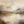 Large hand-painted abstract oil painting of misty mountains and a calm lake in earthy beige and gold tones, styled in a minimalist Wabi Sabi living room.
