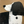 A large hand-painted abstract oil painting of a dog in black and white on a textured tan background, displayed in a minimalist modern living room setting.
