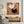 Hand-painted heavy texture oil painting of a white bird and a black bird with button eyes, flying against a textured background of gold, terracotta, and ochre brown paint strokes.