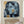 Hand-painted modern abstract cubism oil painting showing multiple overlapping geometric profiles of human faces in shades of slate blue, black, and cream white with patches of ochre gold.