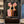 Handcrafted abstract floral oil painting featuring textured pink flowers and portraits against a dark background hanging in a modern living room