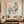 Hand-painted heavy texture abstract oil painting showing clustered blooming flowers in shades of blush pink and peach coral on a refreshing mint green and white background with artistic paint drips.