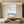 Hand-painted abstract ocean oil painting with thick horizontal texture in blue and beige tones, displayed in a modern boho living room.