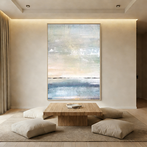 Hand-painted abstract ocean oil painting with thick horizontal texture in blue and beige tones, displayed in a modern boho living room.