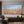 100% handmade impressionist abstract oil painting depicting a vibrant pink flower field under a blue sky, displayed in a modern living room setting.