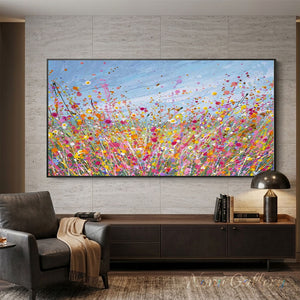 100% handmade impressionist abstract oil painting depicting a vibrant pink flower field under a blue sky, displayed in a modern living room setting.