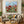 Premium handmade abstract oil painting depicting crimson red poppies and tall green stems under a sky blue sky, rendered with rich 3D palette knife impasto texture.