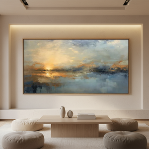 Large horizontal handmade oil painting of an abstract ocean sunset with golden sunlight reflecting on blue waves, styled in a minimalist living room with neutral-colored floor cushions and a wooden table.