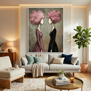 Handmade modern romantic abstract oil painting portraying two faceless female silhouettes with their hair styled into a voluminous 3D textured bouquet of pink and white flowers, olive leaves, and gold leaf on a cream background.