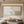 Handmade minimalist abstract oil painting featuring large geometric blocks of beige and cream with heavy impasto texture, styled in a warm, modern living room above a low wooden table.