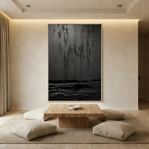 Large vertical black abstract oil painting with heavy 3D drip texture and relief strokes, hanging in a modern minimalist living room with Japanese zen furniture.