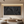 Large handmade black oil painting featuring heavy impasto brushstrokes and 3D textures, styled in a minimalist modern living room above a low wooden table with neutral decor.