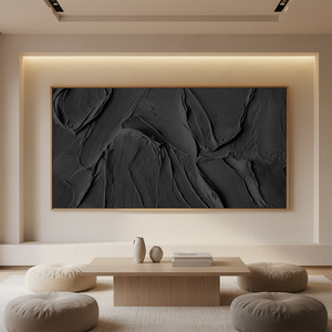 Large handmade black oil painting featuring heavy impasto brushstrokes and 3D textures, styled in a minimalist modern living room above a low wooden table with neutral decor.