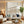 Large handmade 3D abstract canvas art featuring heavy plaster textures of sand ridges and ocean wave reliefs in neutral beige and cream tones, framed in white and displayed on a modern warm-lit living room wall above a grey fabric sofa.