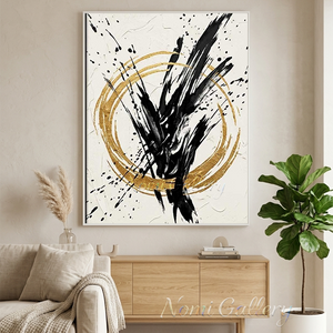 Large handmade abstract canvas painting showcasing a textured plaster circle embellished with shiny gold foil on a cream beige background, styled on a minimalist living room wall above a beige sofa with fluffy pillows.