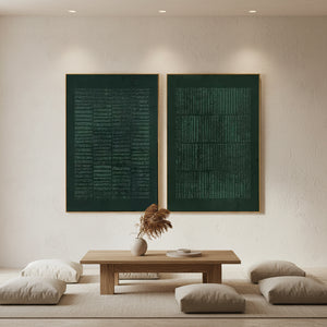 Pair of deep green handcrafted abstract oil paintings featuring vertical 3D linear textures, displayed as a diptych on a white stone wall in a modern living room.