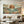 100% handmade boho coastal landscape oil painting featuring a golden sun, ocean waves, and coastal mountains in warm earth tones, displayed in a modern living room setting.