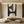 Large handmade Wabi Sabi abstract oil painting on canvas featuring black and brown geometric shapes with visible fabric texture in a boho-style living room.