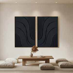 Set of two hand-painted minimalist abstract paintings in matte black featuring vertical 3D ridges and fluid sculptural wave-like textures, creating a rhythmic Zen aesthetic.