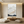 Hand-painted minimalist snow mountain oil painting with heavy 3D impasto texture in white and grey, styled in a bright modern boho living room.