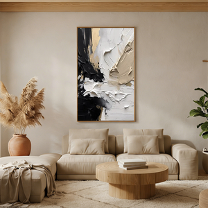 Hand-painted abstract oil painting with thick 3D impasto texture in black, white, and gold, displayed in a bright modern boho living room above a beige sectional sofa.
