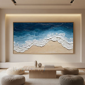 Close-up of a 100% hand-painted abstract oil painting showcasing thick 3D textured impasto ocean waves in deep blue and white crashing onto a sandy beige shoreline.