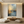 Hand-painted Wabi-Sabi abstract oil painting featuring a golden sunrise over misty blue mountains, styled in a minimalist boho living room above a beige sofa.