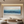 Hand-painted 3D textured abstract painting of blue ocean waves with heavy white impasto foam, displayed in a bright modern coastal-style living room.