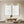 A pair of hand-painted 3D white textured plaster art canvases with bold sculptural ridges, styled in a minimalist sunlit living room above a low wooden table and neutral floor cushions.