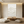Hand-painted 3D textured white mountain oil painting with heavy impasto ridges, displayed in a minimalist boho living room above a beige sectional sofa.