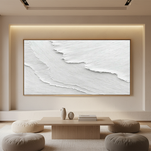 Large handmade white oil painting of a crashing ocean wave with heavy 3D impasto texture, styled in a minimalist modern living room above a wooden console table.