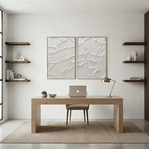 Pair of hand-painted white abstract paintings with heavy diagonal 3D impasto brushstrokes, shown in a modern minimalist living room featuring a wooden table and low seating.