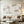 A detailed view of a 100% hand-painted minimalist oil painting featuring thick 3D textured off-white impasto blocks on a beige sandy background with a fine grid engraved in the center.