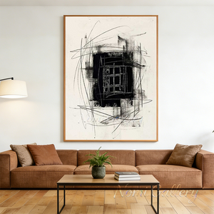 Hand-painted abstract black and white oil painting with textured charcoal lines and a bold central block, styled on a neutral wall above a boho wabi-sabi living room seating area.