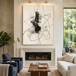 Hand-painted abstract oil painting with fluid black looping lines and a textured smoky black central geometric shape, showcased on a gallery wall above a modern fireplace in a luxury living room.