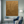 Large hand-painted abstract oil painting featuring shimmering metallic gold foil fluid lines layered over black and clay-colored geometric blocks, showcased on a minimalist white wall in a luxury contemporary living room.