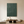 Large 3D textured forest green oil painting featuring geometric arches and vertical lines, hanging in a minimalist beige living room with wooden furniture.