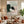 Handmade abstract minimalist oil painting featuring sage green, blush pink, and black textured color blocks with fluid black lines, displayed on a beige wall above a modern living room sofa.