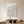 Large hand-painted 3D textured white oil painting depicting abstract snow-capped mountains in a minimalist Boho-style room with a wooden table.