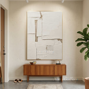 Large original handmade 3D heavy textured minimalist oil painting in plaster white and natural earthy beige tones, styled on a warm beige plaster wall in an upscale Japandi living room above a low wooden table with floor cushions.