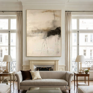 Handmade large minimalist abstract oil painting featuring warm beige and oatmeal tones with an expressive charcoal black sweep and fine vertical lines, styled in a warm Boho living room above a low dark wood table with floor pillows.
