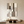 Large hand-painted geometric abstract oil painting with beige and black color blocks and diagonal lines, displayed in a warm minimalist living room setting.