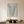 Large hand-painted 3D textured beige abstract oil painting with a sunburst radial pattern, hanging in a bright minimalist living room above a wooden console table.