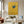 A 100% handmade minimalist oil painting of a single swallow with deep teal wings and a red throat gliding downwards against a textured mustard yellow background with delicate golden grasses in the corner.