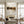 Original handmade modern abstract oil painting featuring bold jet black geometric planes and earthy taupe blocks with sharp linear brushstrokes, showcased on a light neutral wall in an upscale minimalist room.