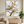 Large original handmade modern abstract oil painting featuring fluid wavy lines in charcoal black and metallic gold leaf, beautifully displayed on a white wall next to a modern staircase with dark wood steps.