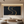 A hand-painted 3D textured oil painting with a deep black background and radiant gold metallic ridges, featuring bold sweeping relief strokes, displayed in a luxury modern living room.