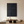 Close-up of a large hand-painted 3D textured black abstract oil painting with heavy cracked earth patterns, styled in a contemporary minimalist living room.